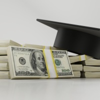 graduation cap on top of stacks of money